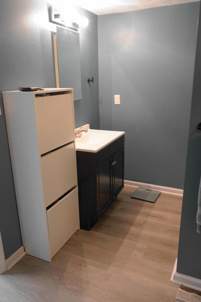 bathroom featuring vanity, baseboards, and wood finished floors