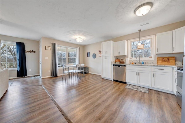 kitchen with a sink, visible vents, white cabinets, and dishwasher