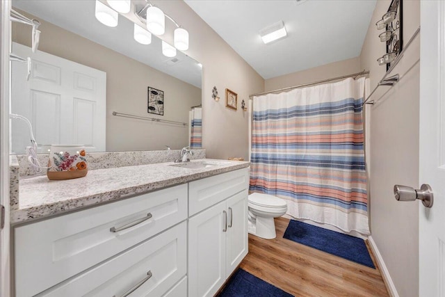 full bath featuring vanity, curtained shower, wood finished floors, and toilet