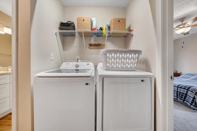 laundry area featuring a ceiling fan, laundry area, light carpet, and separate washer and dryer