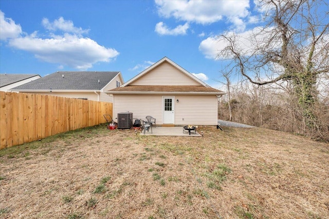 back of house featuring a patio, central AC unit, an outdoor fire pit, fence, and a yard