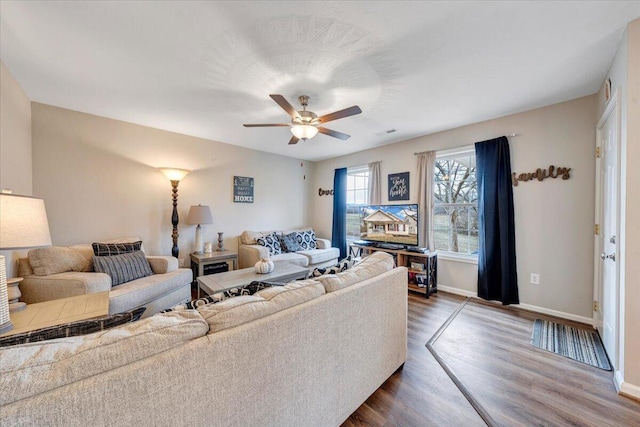 living room featuring dark wood-style flooring, visible vents, ceiling fan, and baseboards