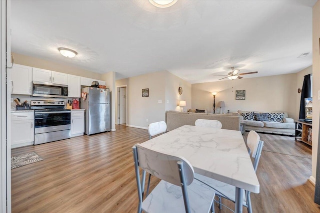 dining area featuring light wood-type flooring, ceiling fan, and baseboards