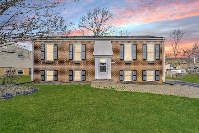 bi-level home featuring a front lawn and brick siding