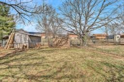 view of yard with fence and an outdoor structure