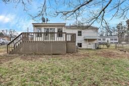 rear view of house with a lawn and a wooden deck