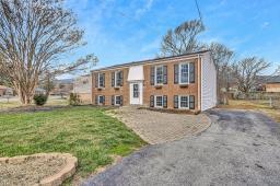 split foyer home with aphalt driveway and a front yard