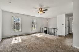 carpeted empty room with a ceiling fan