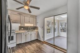 kitchen with ceiling fan, dark wood-style flooring, a sink, light countertops, and stainless steel refrigerator