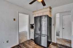 kitchen featuring dark wood-style floors, freestanding refrigerator, and ceiling fan