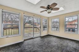 unfurnished sunroom featuring a skylight and ceiling fan