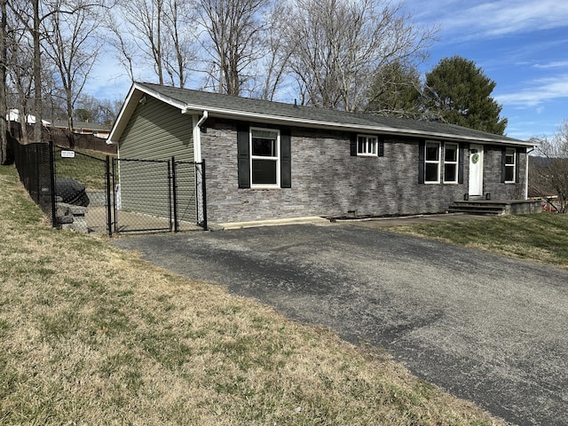 ranch-style house featuring stone siding, a gate, fence, and a front lawn