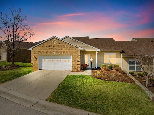 ranch-style home featuring a front lawn, concrete driveway, brick siding, and a garage