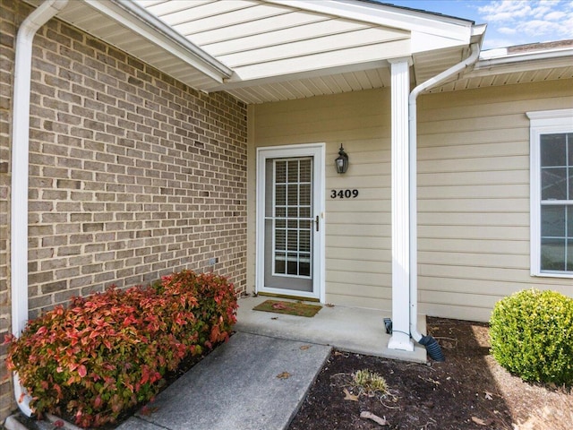 doorway to property with brick siding