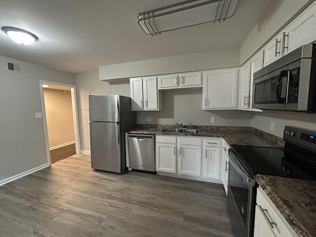 kitchen with visible vents, appliances with stainless steel finishes, white cabinets, and a sink