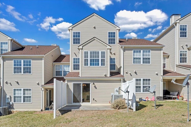 back of property with a yard and a patio