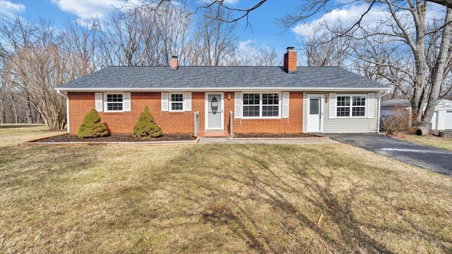 single story home with aphalt driveway, brick siding, a chimney, a shingled roof, and a front lawn