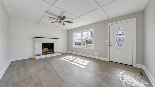 foyer featuring a brick fireplace, baseboards, and wood finished floors