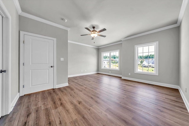 empty room with a ceiling fan, baseboards, wood finished floors, and ornamental molding