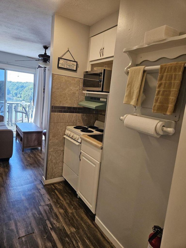 kitchen with a ceiling fan, white range with electric cooktop, stainless steel microwave, white cabinetry, and dark wood-type flooring
