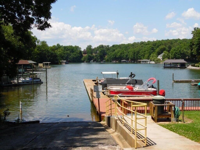 dock area featuring a water view and a wooded view