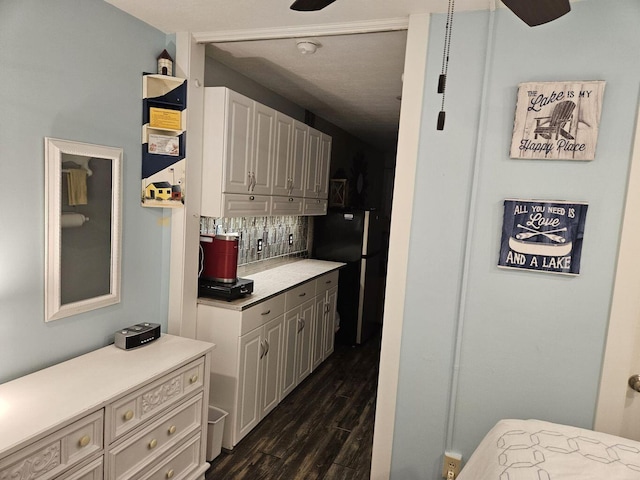 kitchen featuring dark wood-type flooring, light countertops, decorative backsplash, and ceiling fan