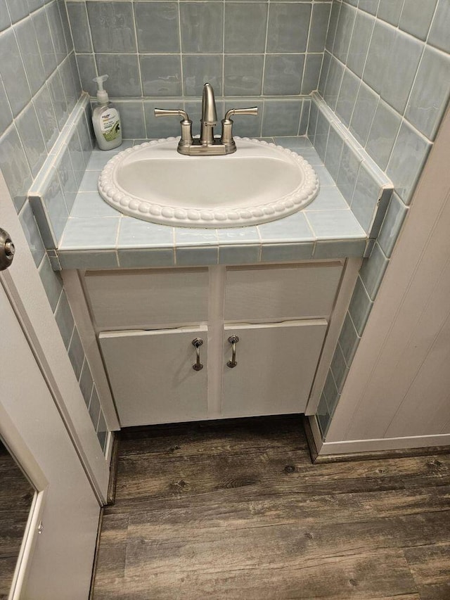 bathroom featuring vanity, decorative backsplash, and wood finished floors