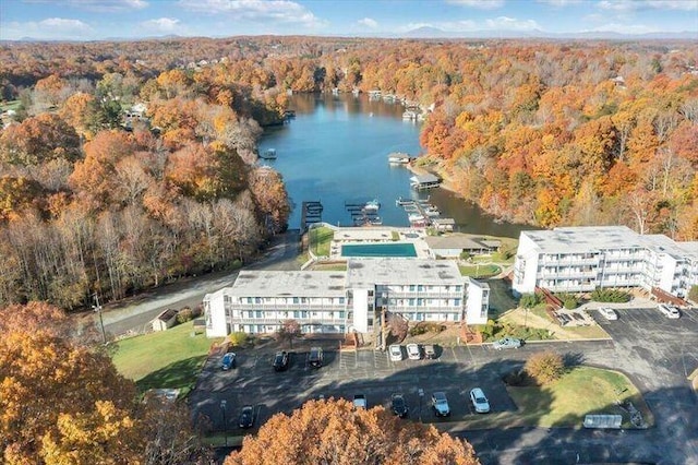 bird's eye view with a water view and a wooded view
