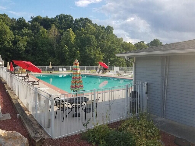 pool with a patio area and fence