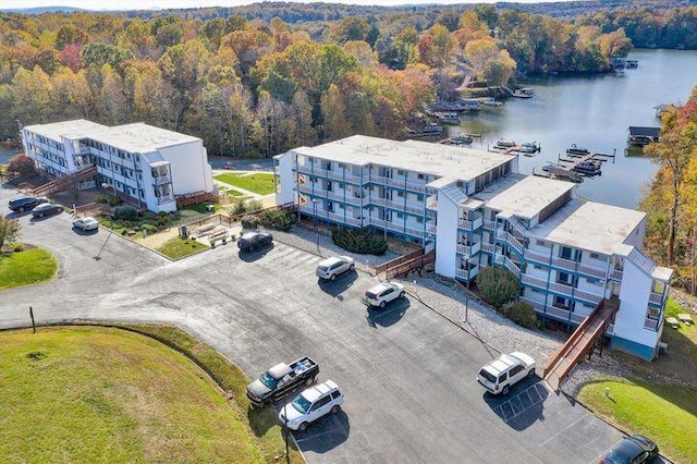 birds eye view of property featuring a forest view and a water view