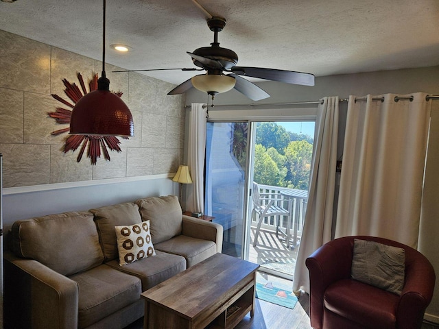 living room featuring a ceiling fan, a textured ceiling, recessed lighting, and wood finished floors