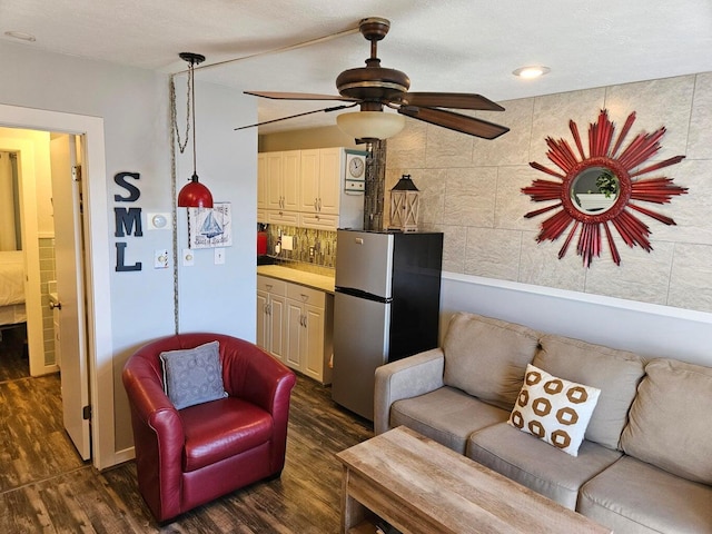 living room with a ceiling fan and dark wood-style floors
