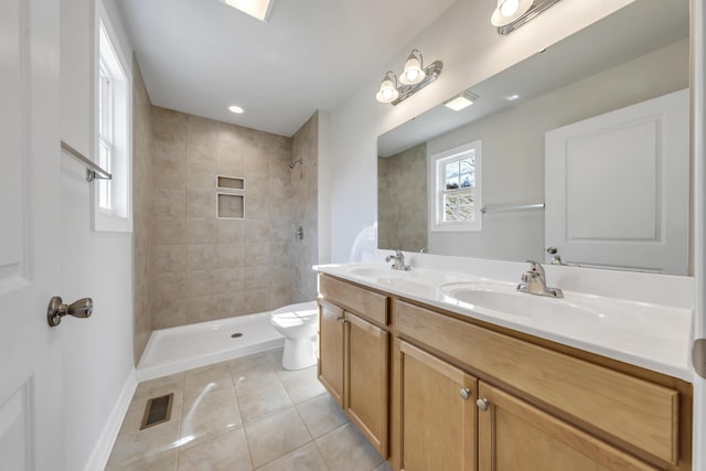 full bathroom with a sink, tile patterned flooring, and tiled shower