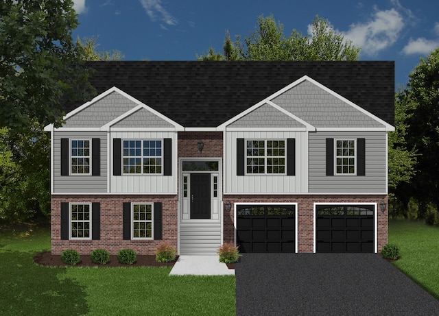 split foyer home featuring a front lawn, driveway, brick siding, and an attached garage