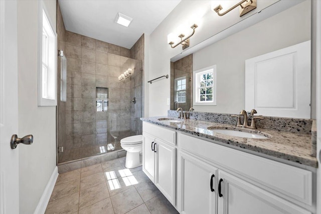 full bathroom featuring baseboards, a sink, a shower stall, and toilet