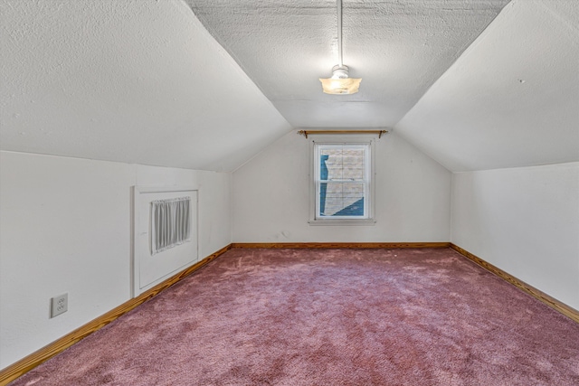 bonus room with lofted ceiling, carpet floors, a textured ceiling, and baseboards