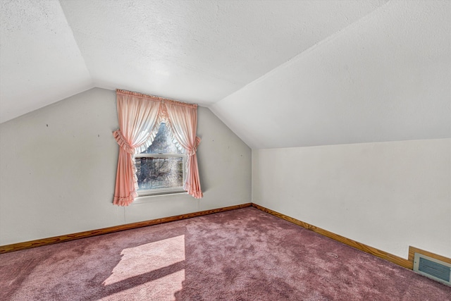 bonus room with carpet, visible vents, vaulted ceiling, a textured ceiling, and baseboards