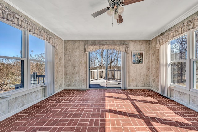 unfurnished sunroom featuring a wealth of natural light and ceiling fan