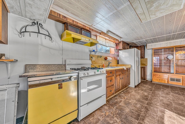 kitchen featuring visible vents, wooden ceiling, a sink, white appliances, and under cabinet range hood