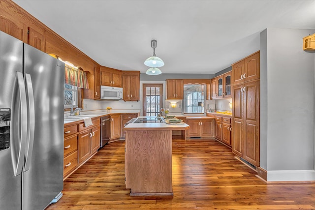 kitchen with stainless steel appliances, dark wood finished floors, light countertops, and a kitchen island