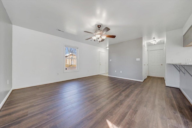 unfurnished living room featuring dark wood-style flooring, ceiling fan, and baseboards