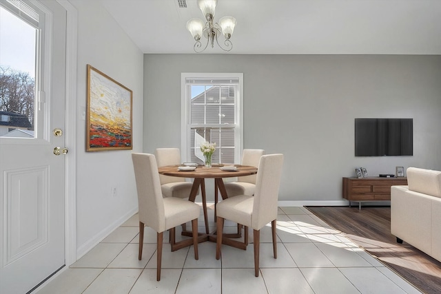 dining room with a chandelier, light tile patterned flooring, visible vents, and baseboards