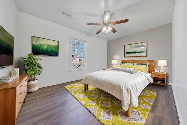 bedroom featuring visible vents, dark wood finished floors, baseboards, and ceiling fan