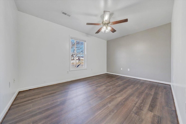 empty room featuring dark wood-style floors, baseboards, visible vents, and a ceiling fan