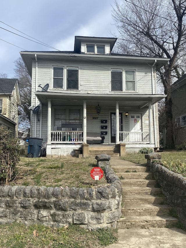 american foursquare style home featuring covered porch