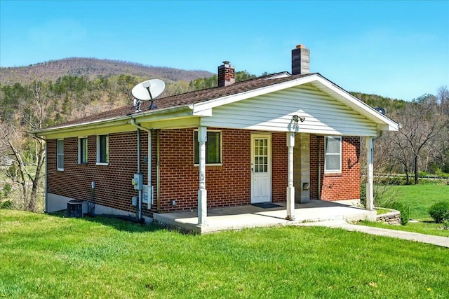 2351 Reese Mountain Rd, Elliston, VA 24087 - rear view of house featuring a lawn, a chimney, and brick siding
