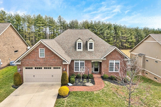 view of front of home featuring driveway, brick siding, a front lawn, and a shingled roof