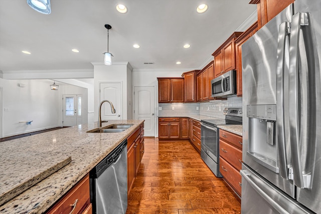 kitchen with appliances with stainless steel finishes, brown cabinets, a sink, and light stone countertops