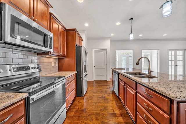 kitchen with appliances with stainless steel finishes, a sink, dark wood finished floors, and crown molding