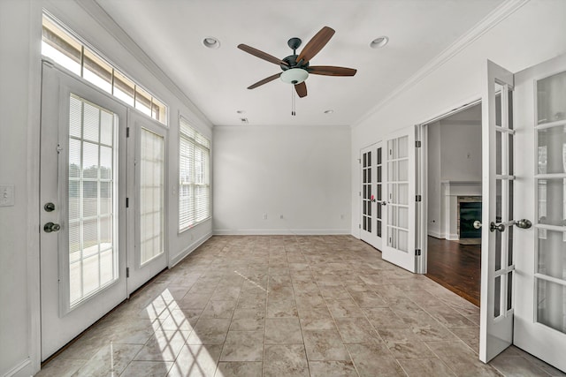 spare room with a ceiling fan, french doors, crown molding, and baseboards